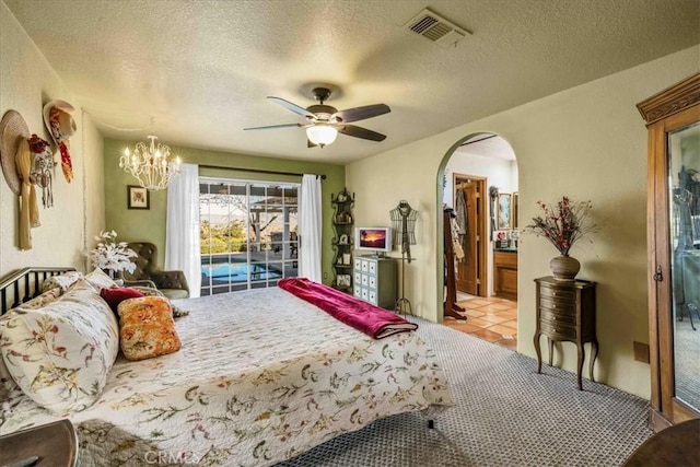 10341 Pinon Ave, Morongo Valley, CA 92256 - bedroom featuring arched walkways, a textured ceiling, a chandelier, a ceiling fan, and ensuite bath