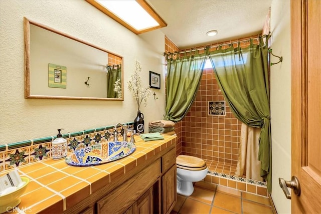 10341 Pinon Ave, Morongo Valley, CA 92256 - bathroom with toilet, tiled shower, tile patterned flooring, and vanity