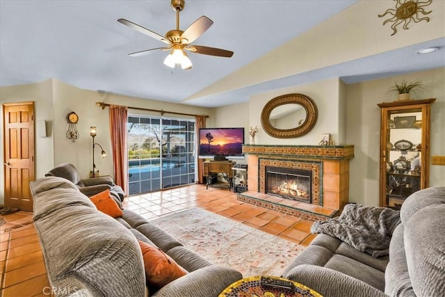 tiled living area featuring a fireplace, lofted ceiling, and ceiling fan