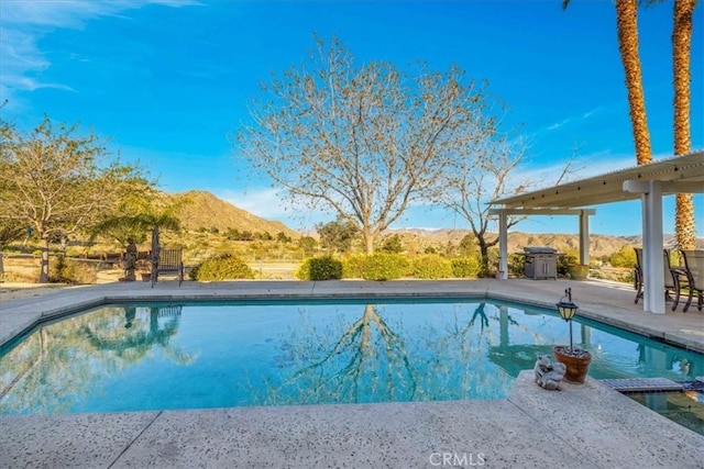 pool with a patio and a mountain view