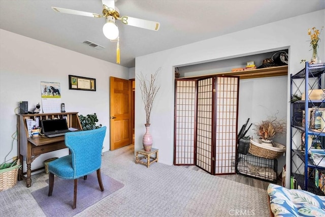 home office with carpet floors, visible vents, and a ceiling fan