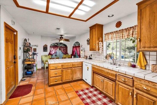 10341 Pinon Ave, Morongo Valley, CA 92256 - kitchen with dishwasher, decorative backsplash, a sink, brown cabinets, and recessed lighting