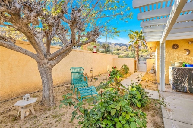 view of yard with a gate, fence, and a mountain view
