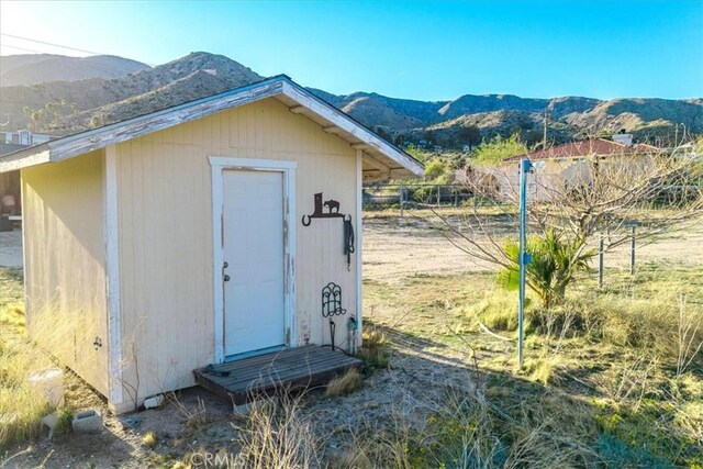 view of shed featuring fence and a mountain view