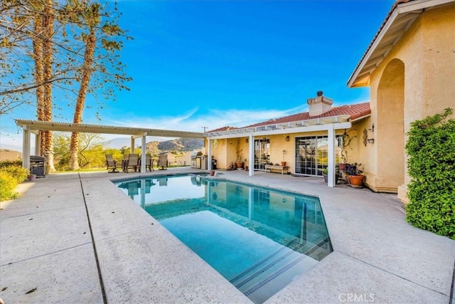 outdoor pool featuring a pergola and a patio area