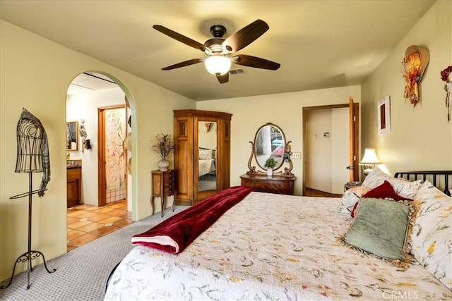 10341 Pinon Ave, Morongo Valley, CA 92256 - bedroom featuring arched walkways, light tile patterned floors, ceiling fan, and ensuite bath