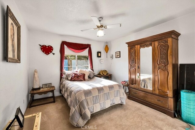 bedroom with a ceiling fan and light carpet