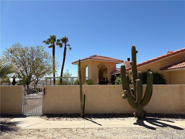 10341 Pinon Ave, Morongo Valley, CA 92256 - view of front of home with a gate, a tile roof, and stucco siding
