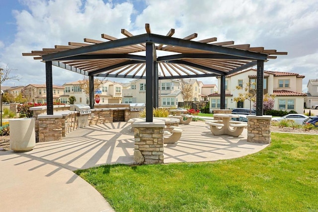 view of patio featuring a pergola, a residential view, grilling area, and exterior kitchen