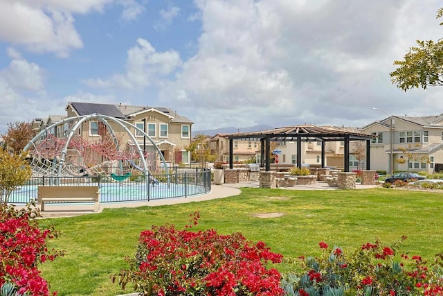 view of property's community featuring a residential view, fence, and a lawn