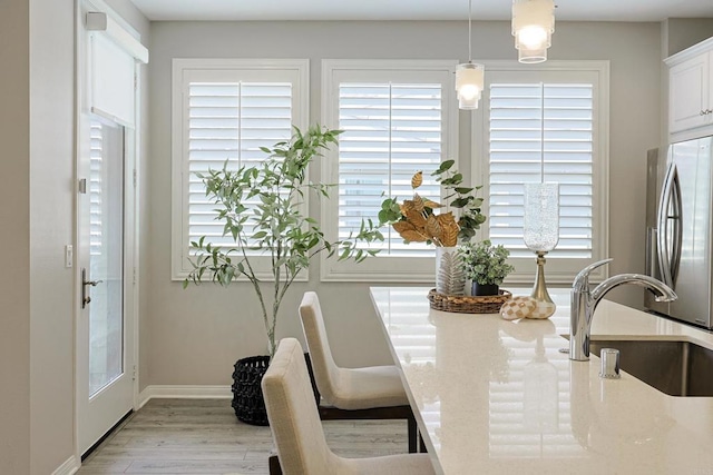 dining area with light wood-style flooring and baseboards