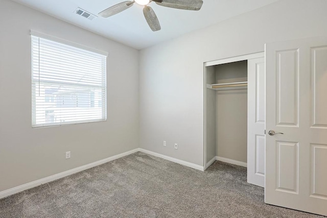 unfurnished bedroom with carpet, a closet, a ceiling fan, visible vents, and baseboards