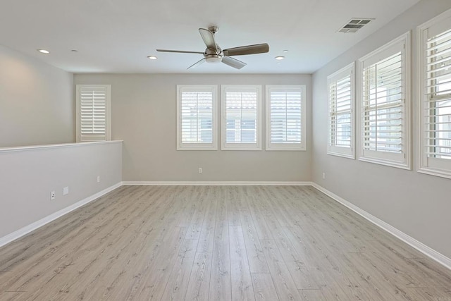 unfurnished room featuring visible vents, wood finished floors, a ceiling fan, and a healthy amount of sunlight