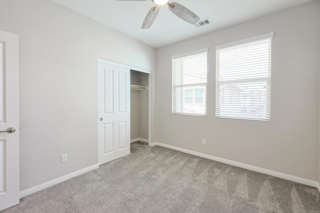 unfurnished bedroom with carpet, a closet, baseboards, and a ceiling fan
