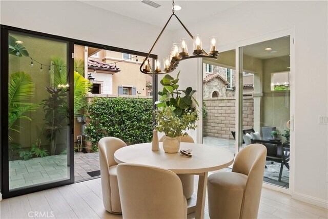 dining space featuring a chandelier and baseboards