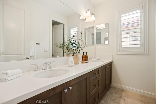 full bathroom featuring baseboards, double vanity, and tile patterned floors