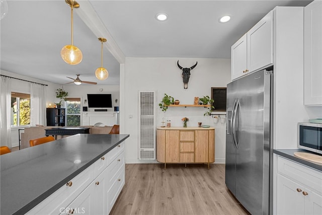 kitchen featuring a ceiling fan, white cabinets, appliances with stainless steel finishes, dark countertops, and light wood finished floors