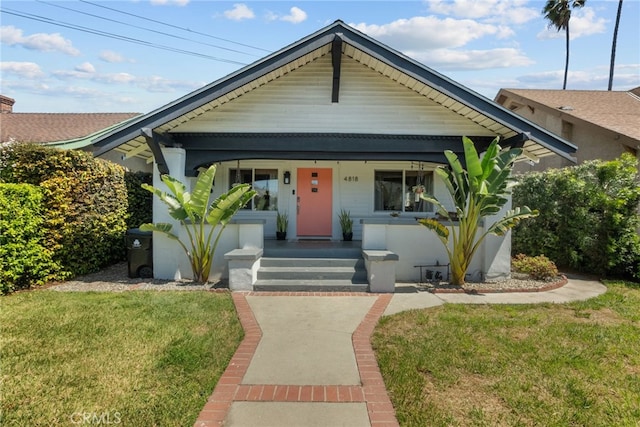 bungalow featuring a porch and a front lawn