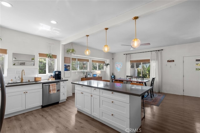 kitchen with a sink, white cabinets, dark countertops, and dishwasher