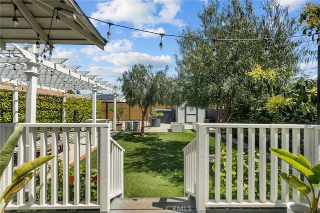view of yard with an outbuilding, a pergola, and fence
