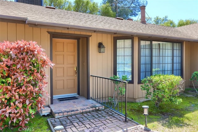 44410 Quail Ct, Coarsegold, CA 93614 - view of exterior entry with board and batten siding and a shingled roof
