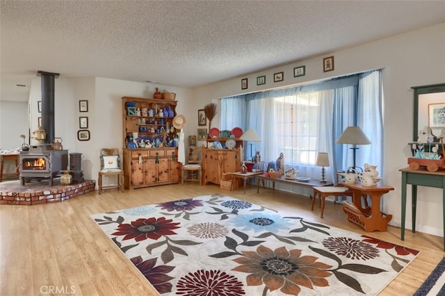 44410 Quail Ct, Coarsegold, CA 93614 - sitting room featuring a wood stove, a textured ceiling, and wood finished floors