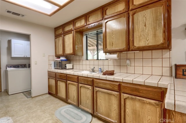 44410 Quail Ct, Coarsegold, CA 93614 - kitchen featuring brown cabinets, visible vents, stainless steel microwave, and decorative backsplash