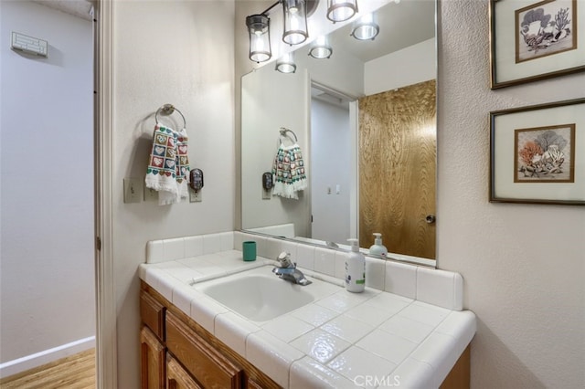 44410 Quail Ct, Coarsegold, CA 93614 - bathroom featuring baseboards, vanity, and wood finished floors