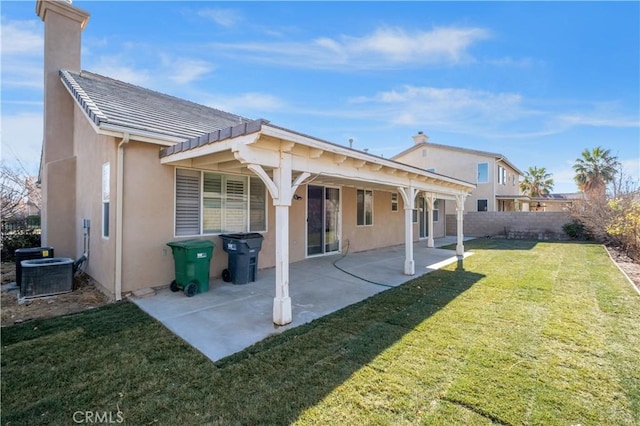 rear view of house with stucco siding, central air condition unit, a yard, and a patio