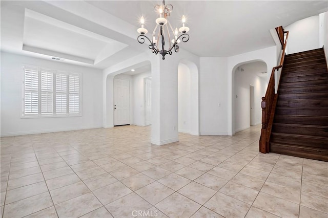 empty room featuring baseboards, an inviting chandelier, stairway, light tile patterned flooring, and arched walkways