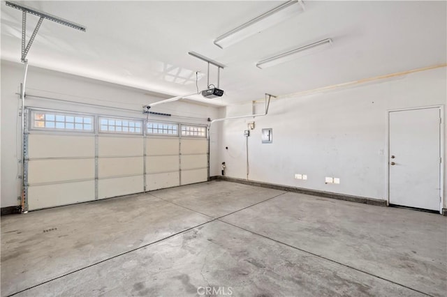 garage with baseboards and a garage door opener