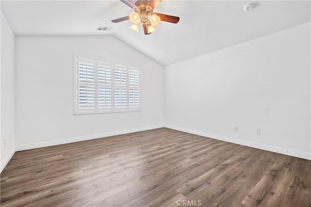 empty room with a ceiling fan, visible vents, wood finished floors, lofted ceiling, and baseboards