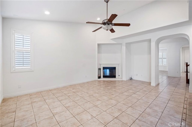 unfurnished living room featuring light tile patterned floors, arched walkways, a ceiling fan, recessed lighting, and high vaulted ceiling