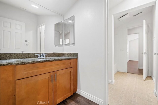 bathroom featuring vanity, baseboards, and lofted ceiling