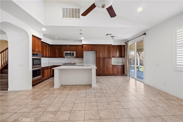kitchen with vaulted ceiling, light countertops, light tile patterned flooring, visible vents, and stainless steel appliances
