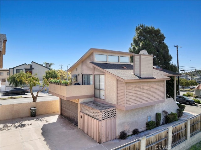 2707 Vanderbilt Ln Unit 1, Redondo Beach, CA 90278 - view of front of home with a chimney, stucco siding, roof with shingles, and a balcony