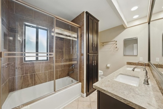 bathroom with tile patterned floors, double vanity, enclosed tub / shower combo, toilet, and a sink