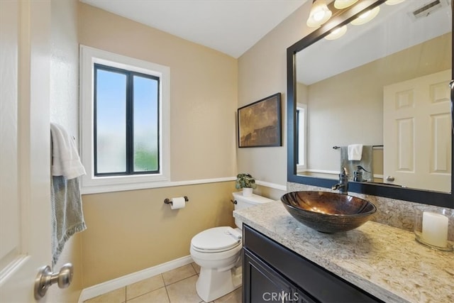 half bath with visible vents, baseboards, toilet, vanity, and tile patterned flooring