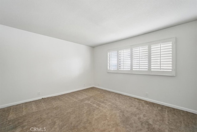 carpeted empty room with baseboards