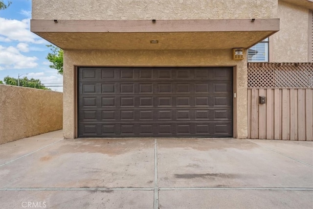 garage featuring fence and driveway