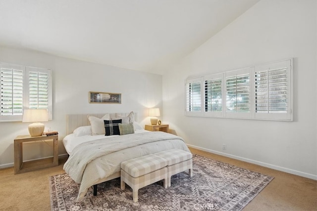 carpeted bedroom featuring high vaulted ceiling and baseboards