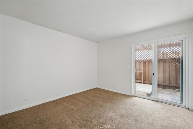 carpeted spare room featuring baseboards