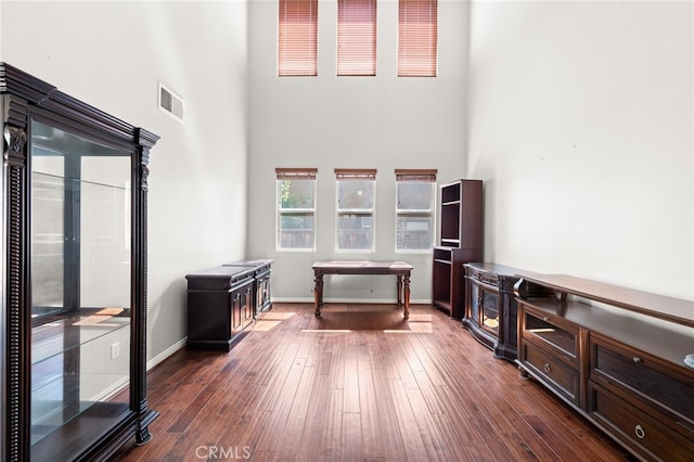 16219 Skyridge Dr, Riverside, CA 92503 - living room featuring a towering ceiling, dark wood-style flooring, and baseboards