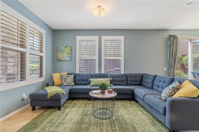 tiled living area with baseboards and visible vents