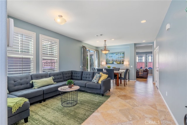 living area with recessed lighting, plenty of natural light, visible vents, and baseboards