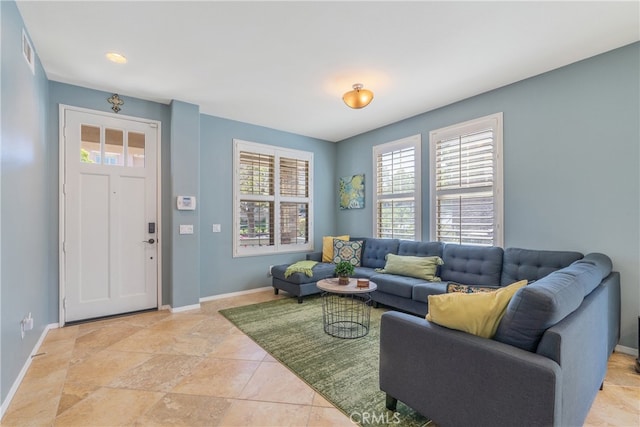 living area with baseboards and visible vents
