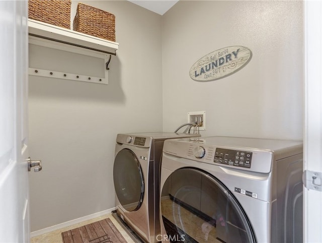 laundry room featuring baseboards, washer and clothes dryer, and laundry area