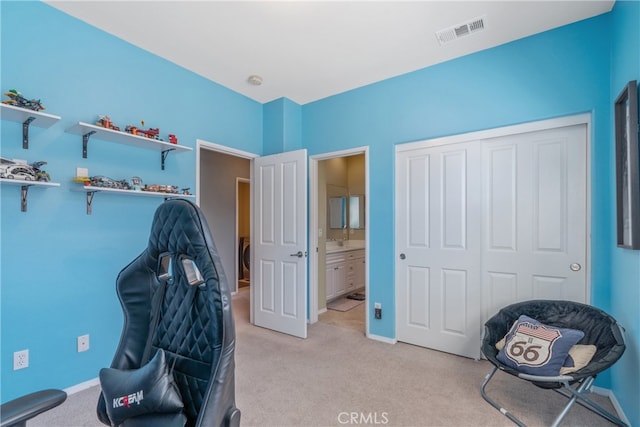 bedroom featuring visible vents, light carpet, ensuite bath, a closet, and baseboards