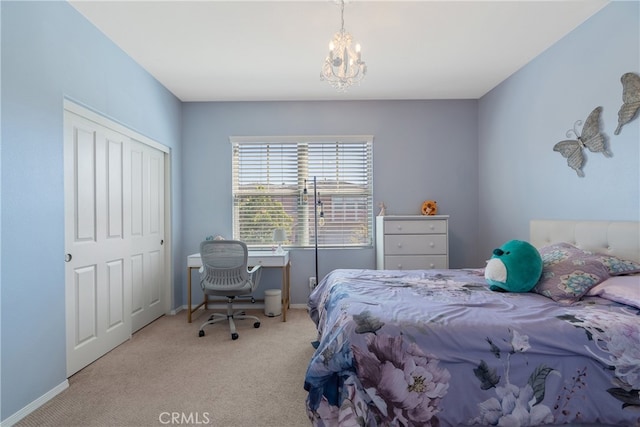 bedroom with baseboards, carpet flooring, a notable chandelier, and a closet