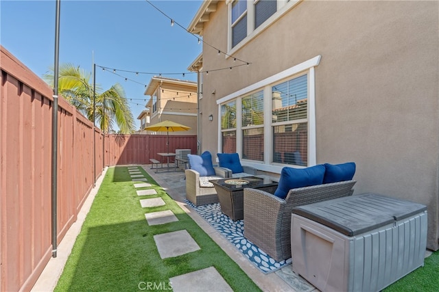 view of yard with an outdoor living space with a fire pit, a patio, and a fenced backyard